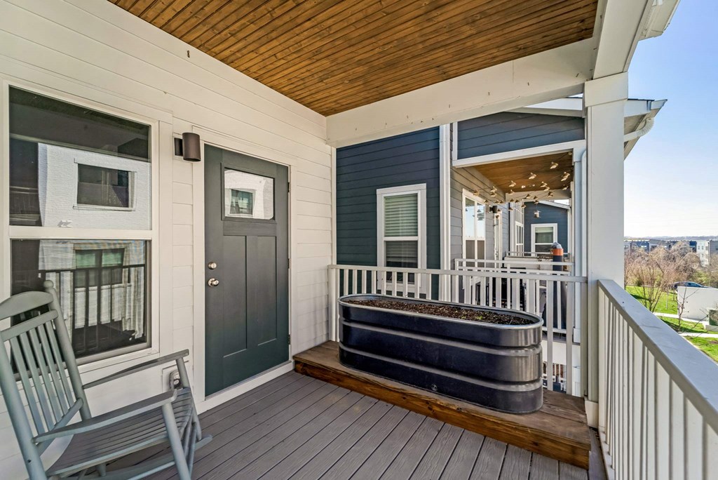 a covered porch with a hot tub on it