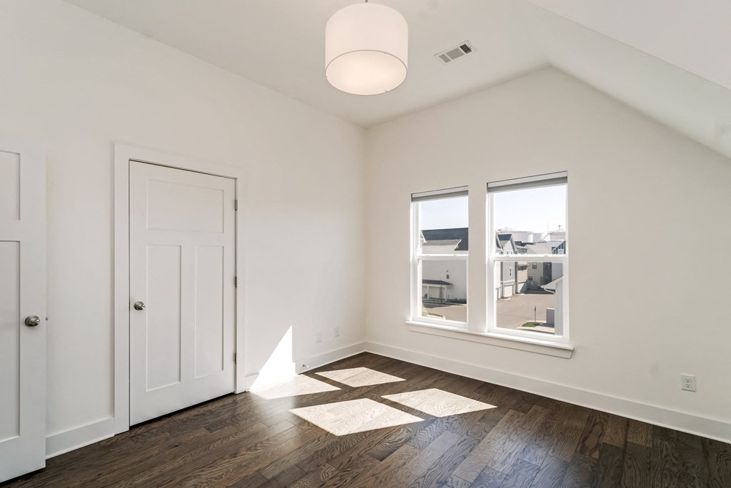 a living room with white walls and a window and a door