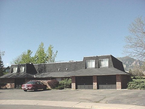 A house with a red car parked in front.