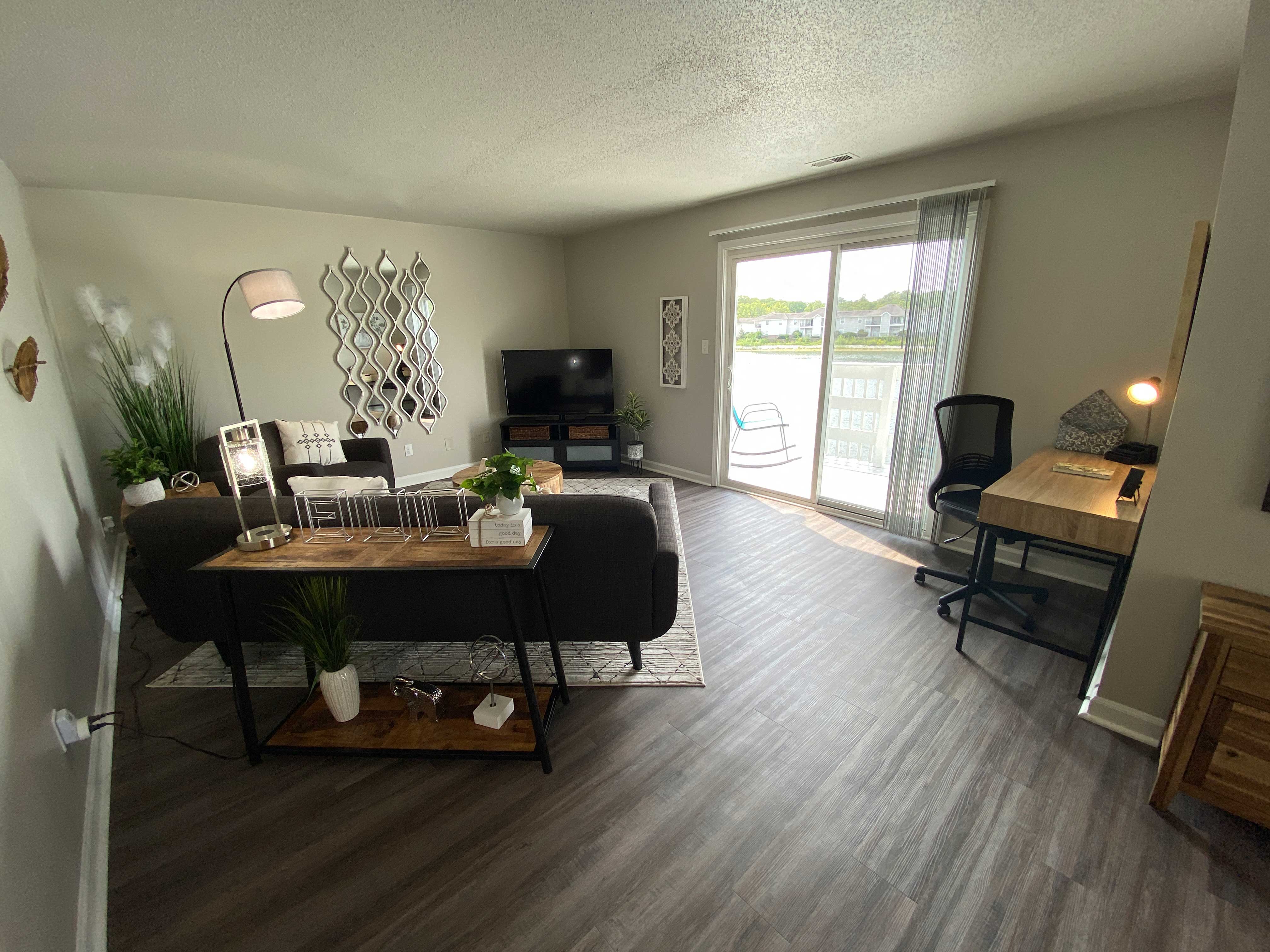 A living room with a black couch and a wooden coffee table.