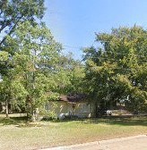 a house in the middle of a field with trees
