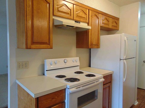 A white stove and oven in a kitchen with wooden cabinets.