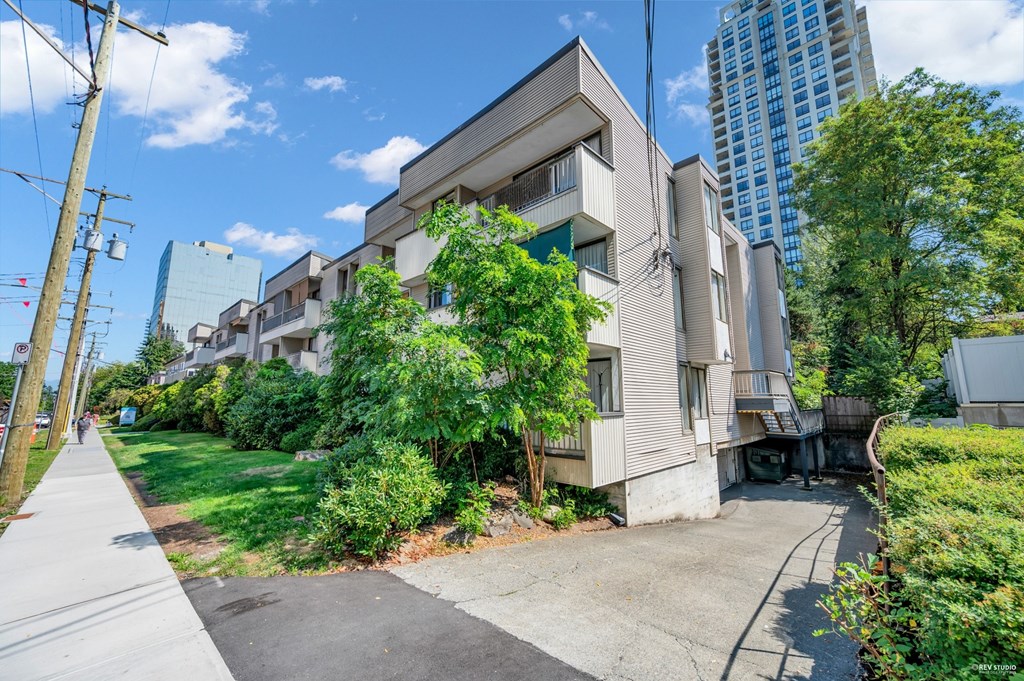 A residential building with a green lawn in front.
