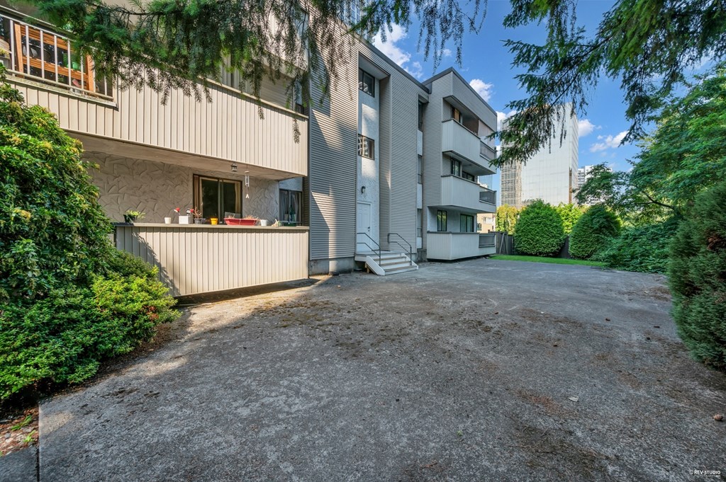 A gravel driveway leads to a modern two-story house with a garage.