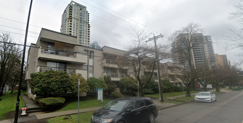 A car is parked on the side of a street in front of a building.