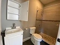 A white toilet sits in a bathroom next to a sink and a shower.