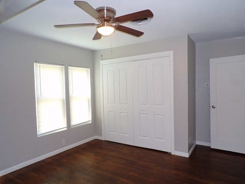 a bedroom with a ceiling fan and a closet