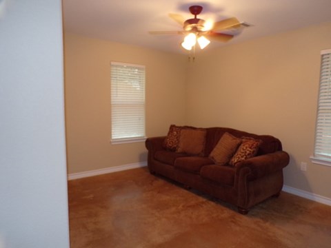 a living room with a couch and a ceiling fan
