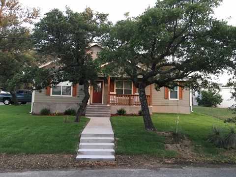 the front of our house with the trees