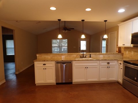 a kitchen with white cabinets and a sink and a refrigerator