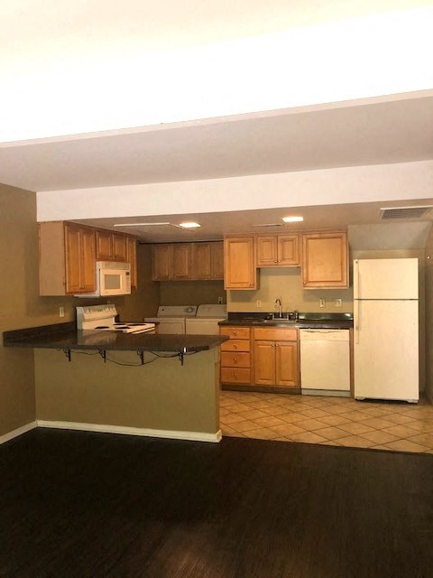 a kitchen with white appliances and wooden cabinets