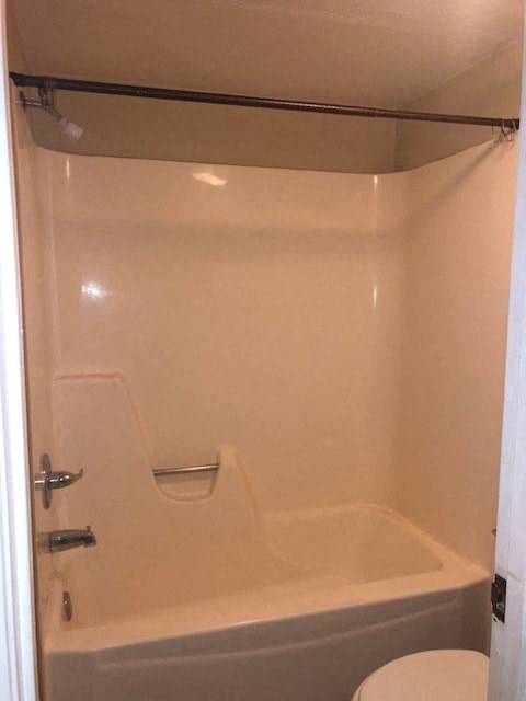 a bathroom with a toilet and a bath tub