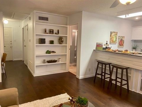A kitchen with white cabinets and a bar area.