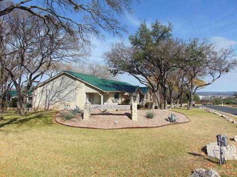 A house with a green roof and a sign that says "LAKE VIE" in front of it.