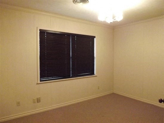 a living room with a large window and a carpet