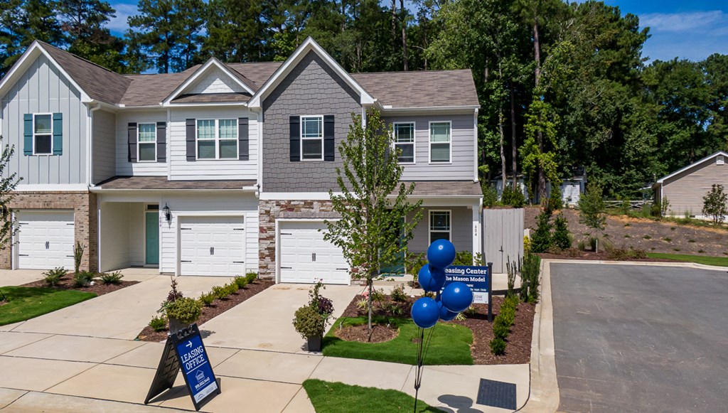a house for sale with blue balloons in front of it