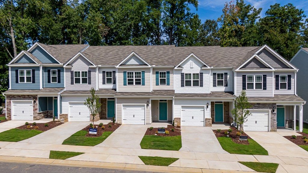 a white house with green doors and shutters on a street