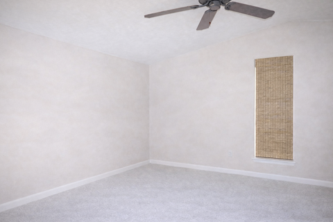 A room with a ceiling fan and a window covered with a screen.
