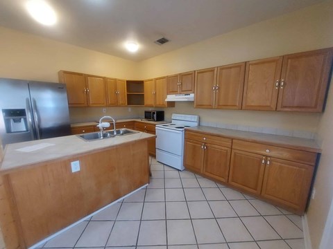 A kitchen with wooden cabinets and white appliances.