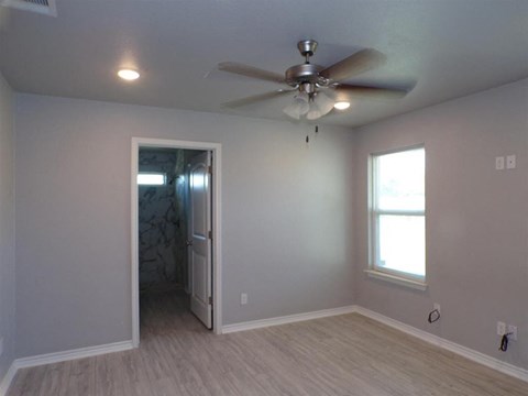a living room with a ceiling fan and a door to a closet
