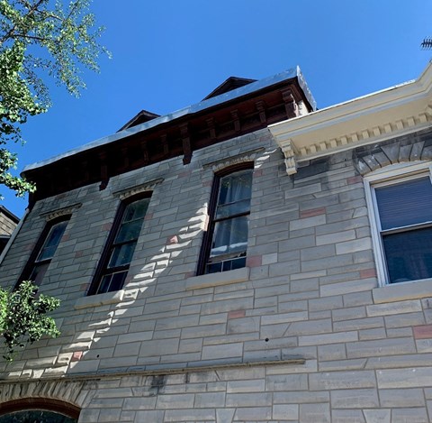 a white brick building with windows and a blue sky