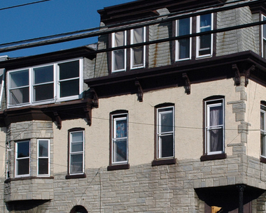 a large stone building with windows and a balcony
