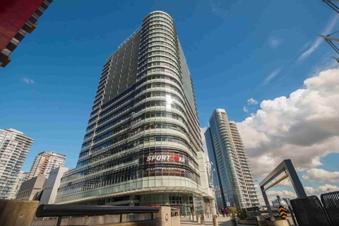 A tall building with a curved facade and a sign that reads #SPORT.