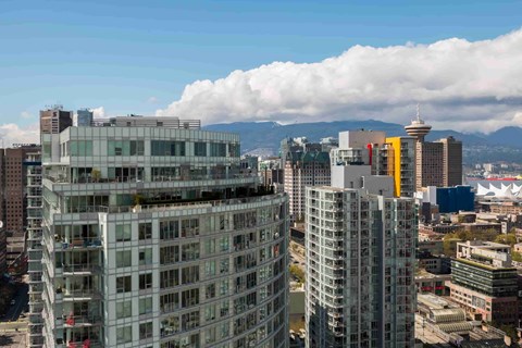 A cityscape with tall buildings and a mountain in the background.