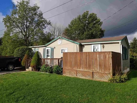 A house with a green roof and a wooden fence.