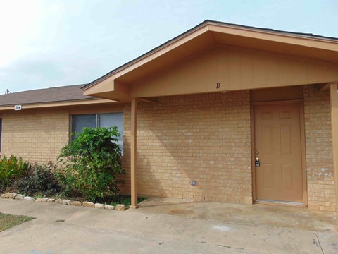 the front of a brick house with a garage door
