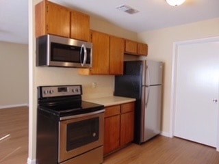 a kitchen with a stove refrigerator and microwave