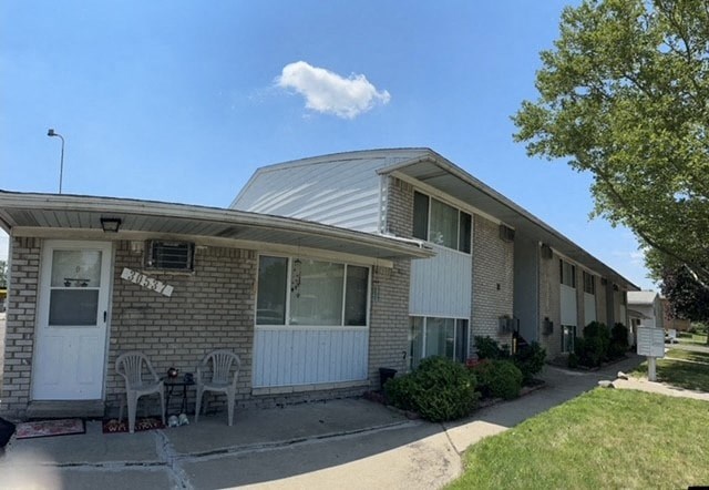 A sunny day at a residential area with a house and a tree.
