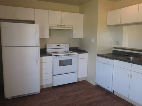 a kitchen with white appliances and white cabinets