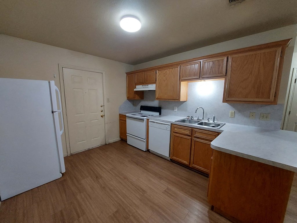 A kitchen with wooden cabinets and white appliances.