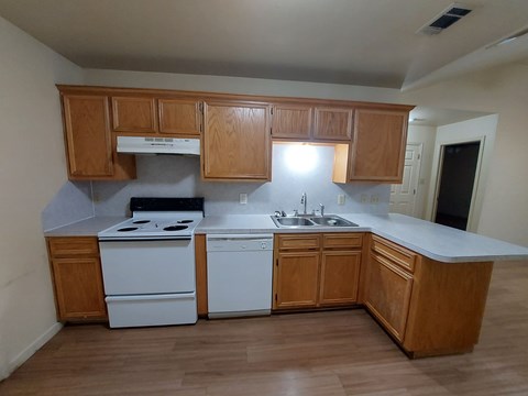 A kitchen with wooden cabinets and white appliances.