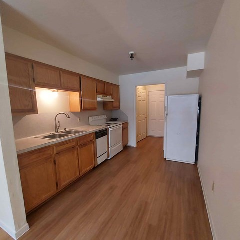 A kitchen with wooden cabinets and a white fridge.