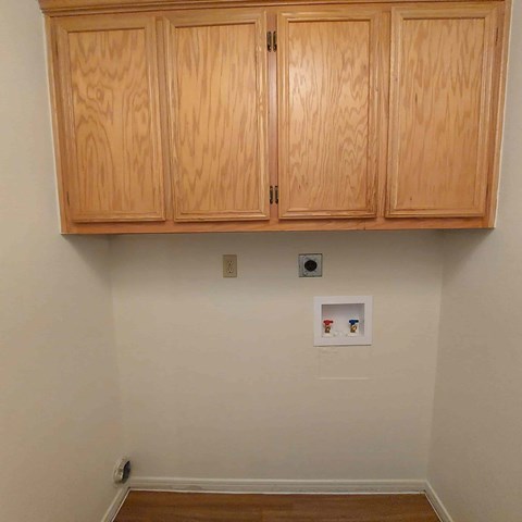 A small picture is hanging on the wall under the cabinets.
