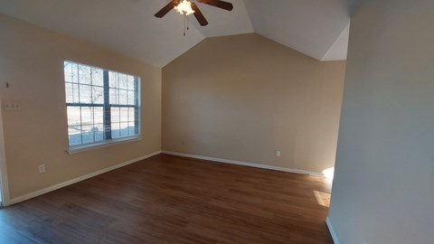 A room with a ceiling fan and a window.