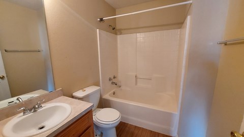 A white bathroom with a toilet, sink, and bathtub.