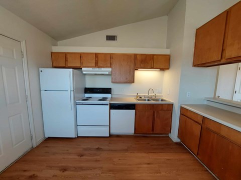 A kitchen with white appliances and wooden cabinets.