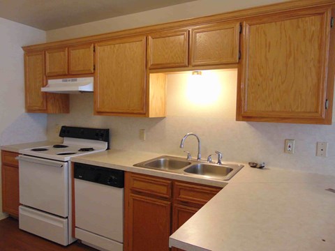 a kitchen with white appliances and wooden cabinets