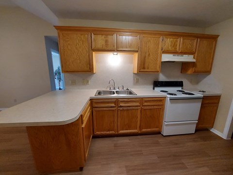 A kitchen with wooden cabinets and a white countertop.
