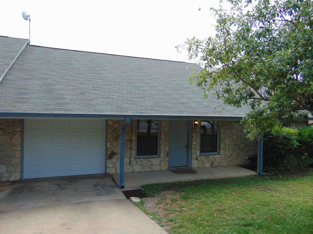 the front of the house has a concrete walkway and a blue door