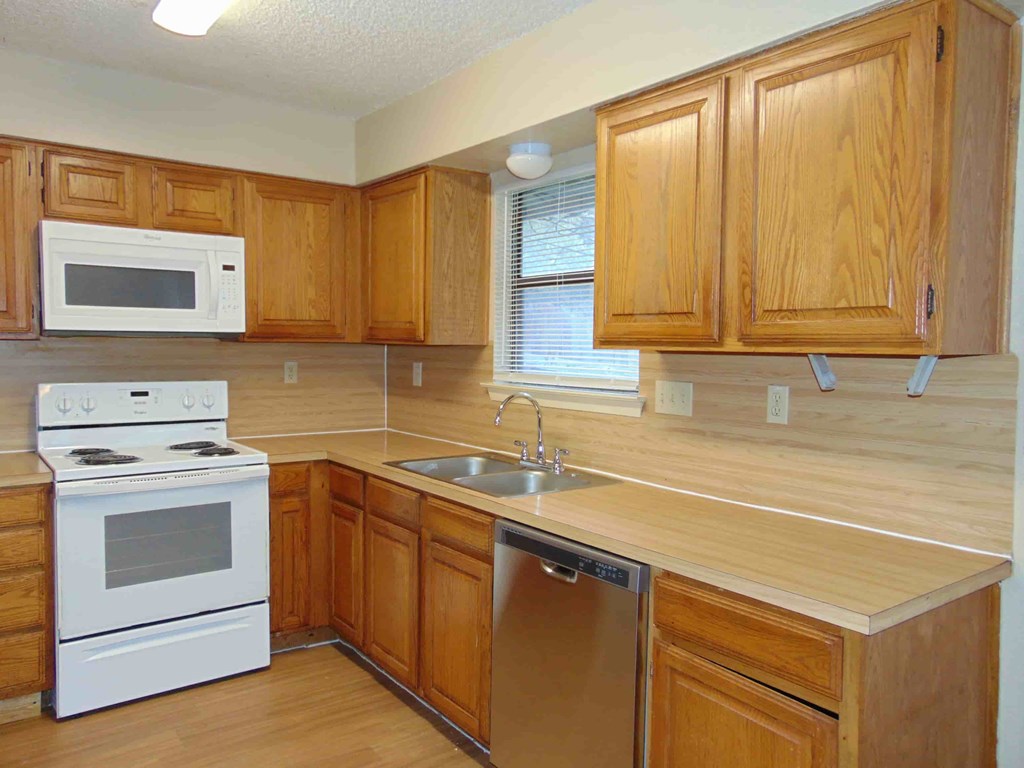 a kitchen with white appliances and wooden cabinets