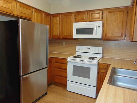 a kitchen with white appliances and wooden cabinets