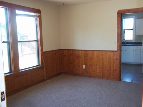 A room with a window and a wooden wall.