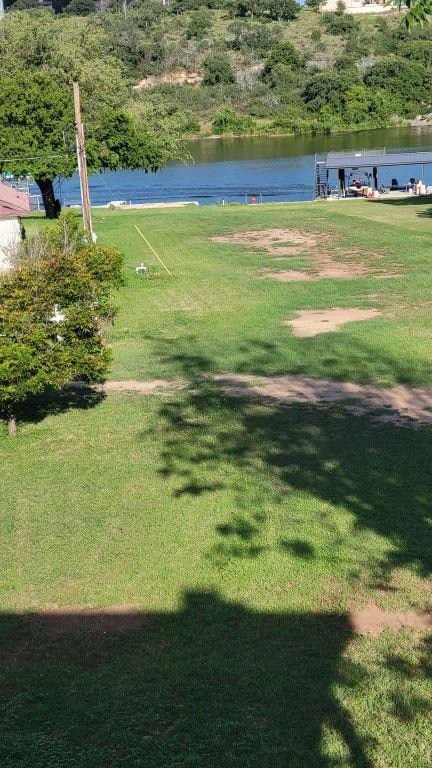 a grass field with a lake in the background