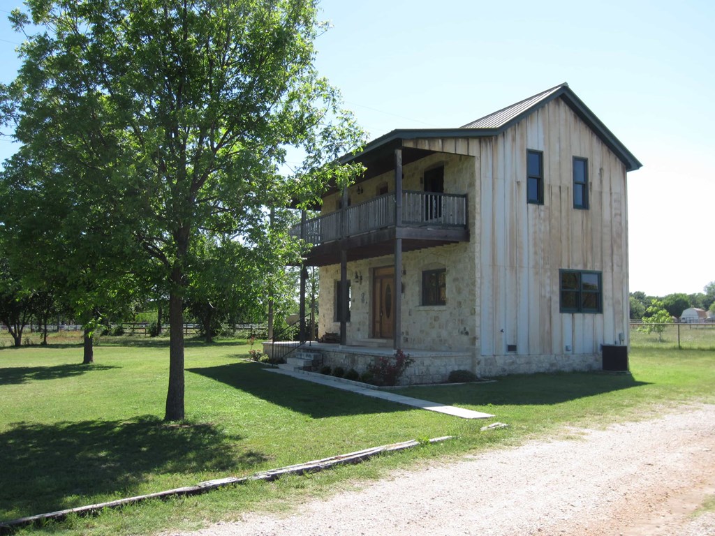 an old barn with a tree in front of it
