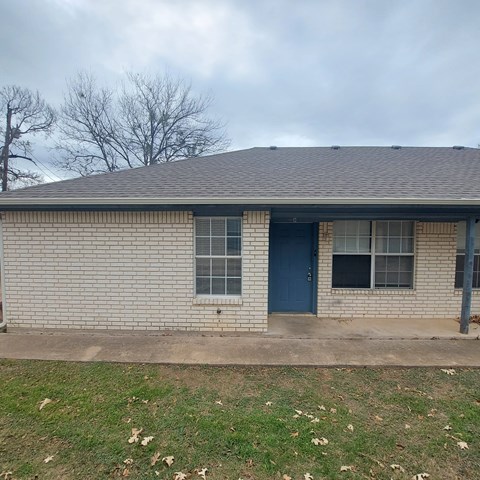 A house with a blue door and a grey roof.