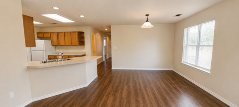 A kitchen with wooden floors and a white countertop.